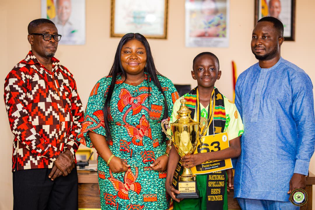 Eugene holds the Peniel Academy championship trophy, posing with adults at the event.